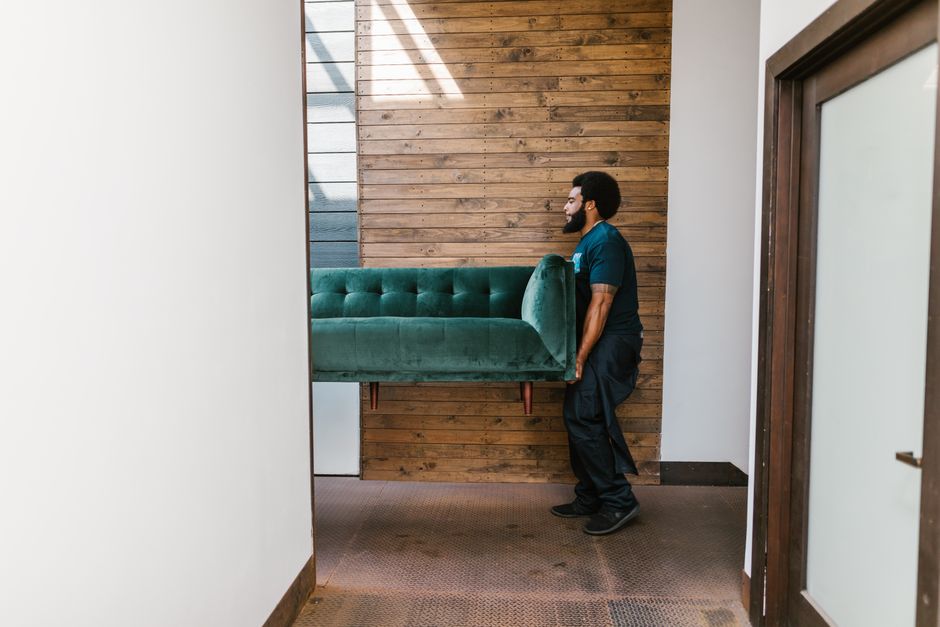 Local movers carrying heavy furniture out of a house